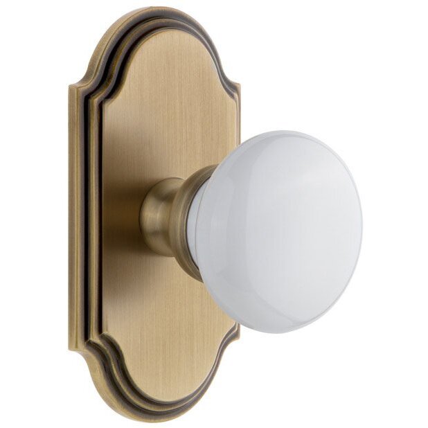Grandeur Arc Plate Double Dummy with Hyde Park White Porcelain Knob in Vintage Brass