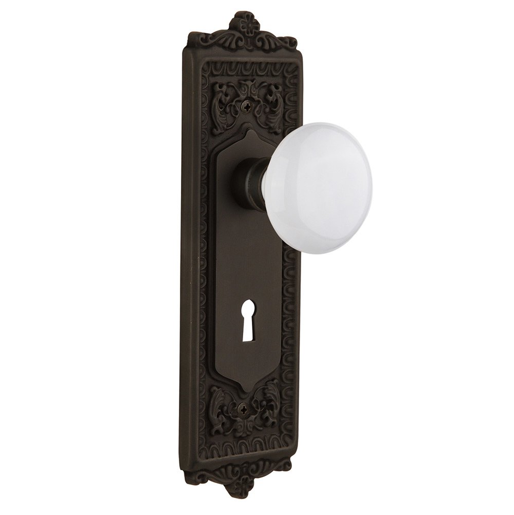 Nostalgic Warehouse Passage Egg & Dart Plate with Keyhole and White Porcelain Door Knob in Oil-Rubbed Bronze